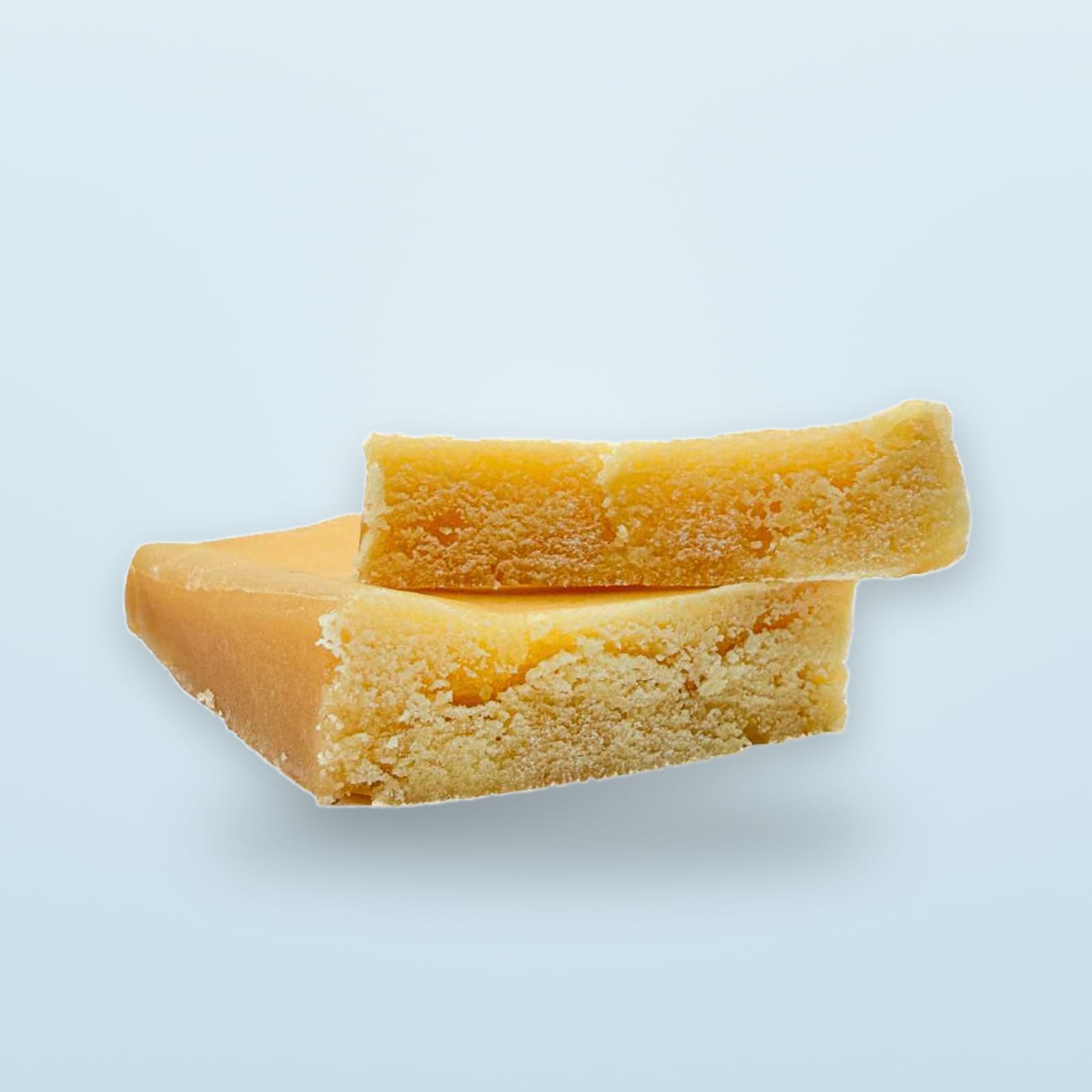 Two slabs of golden crumble stacked on a pale background